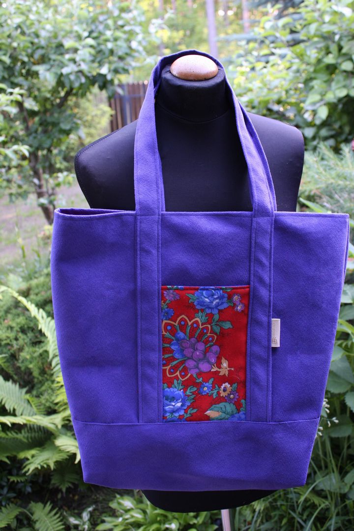 Kobaltowa szoperka z nubuku z czerwoną kieszenią ze wzorem folkowym.