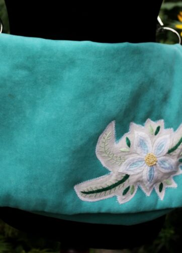 Morska kopertówka z haftowanym kwiatem z obrusa.